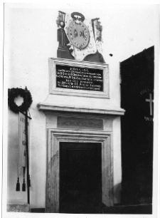 Klewań, Kości&oacute;ł p.w. Zwiastowania Najświętszej Maryi Panny - portal w prezbiterium z wmontowaną nad nim tablicą erekcyjną kościoła zwieńczoną polichromią z medalionem w kt&oacute;rym p&oacute;łksiężyc